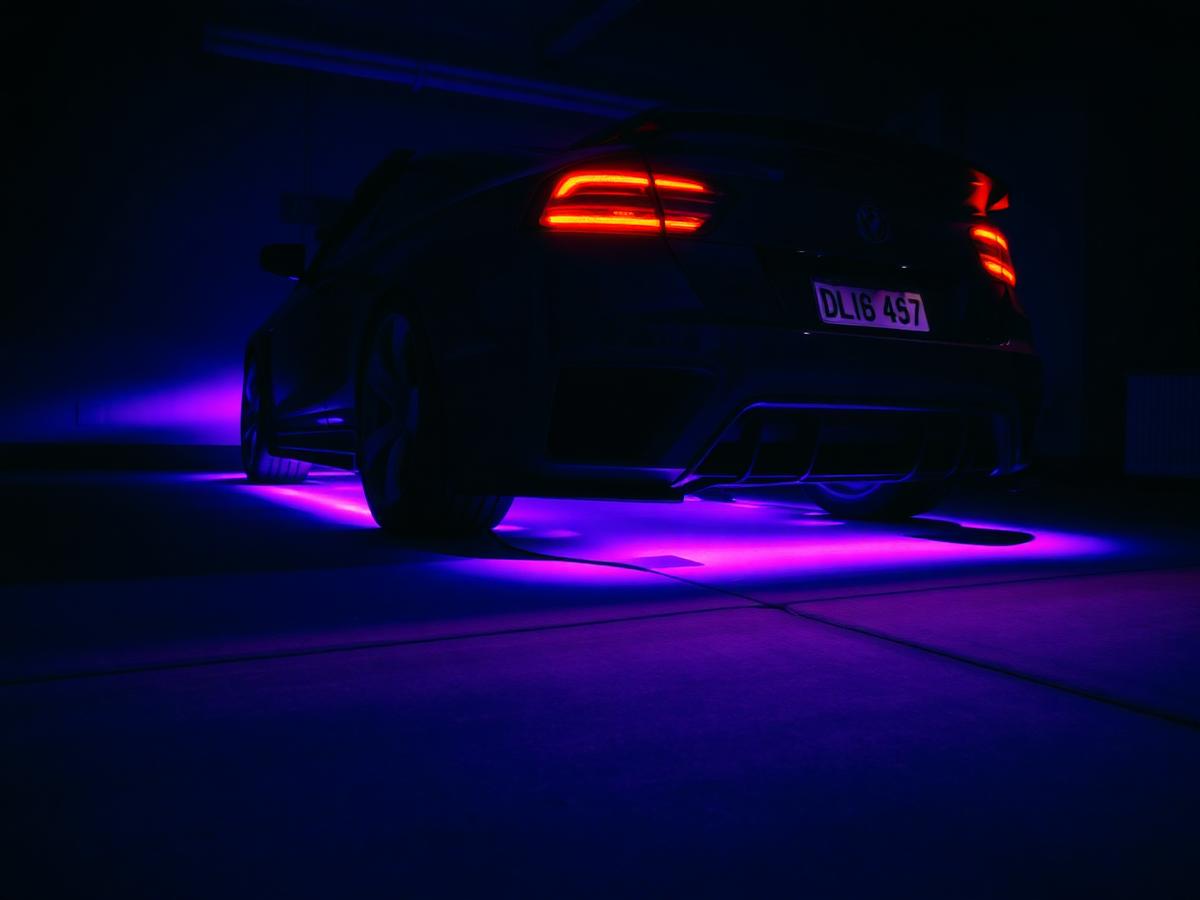 Car with purple LED underglow lighting in a dark garage